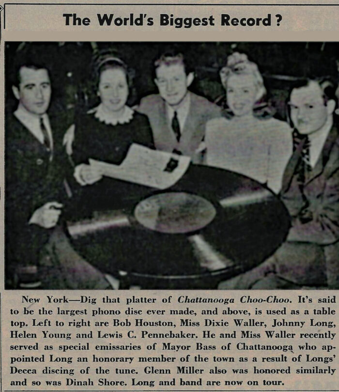 March 1942 Downbeat Magazine scan: Johnny Long posing with a giant novelty record prop on a table for a promotional photo op.